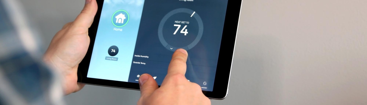 Front view of someone adjusting the temperature using a smart tablet
