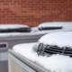 Side view of outdoor HVAC units with snow covering the tops