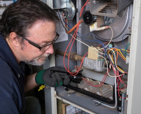 Technician Looking Over A Gas Furnace
