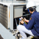 Side view of a technician performing maintenance on a commercial HVAC unit