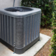 Modern HVAC air conditioner unit on concrete slab outside of house